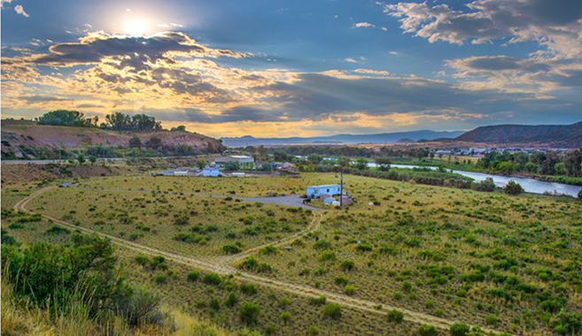 A grassy green landscape beneath a blue sky.