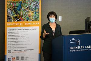 a person giving a talk with a mask on at a podium