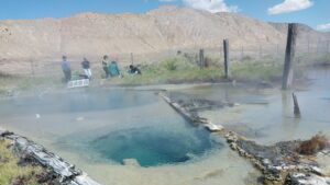 A photo of Great Boiling Spring in the forefront with mountains in the background.