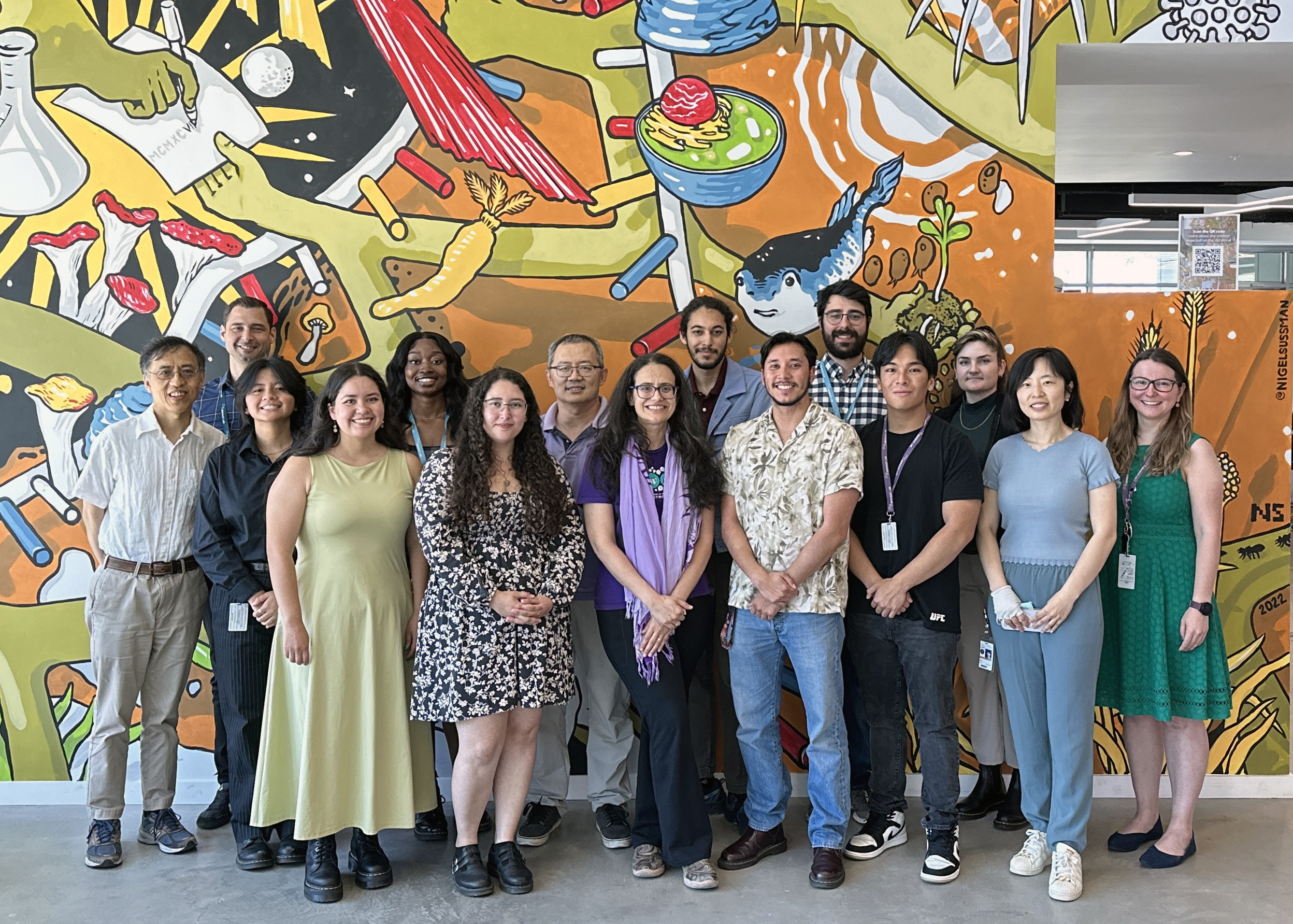 A photo of UC Merced interns with their mentors in front of the JGI Mural