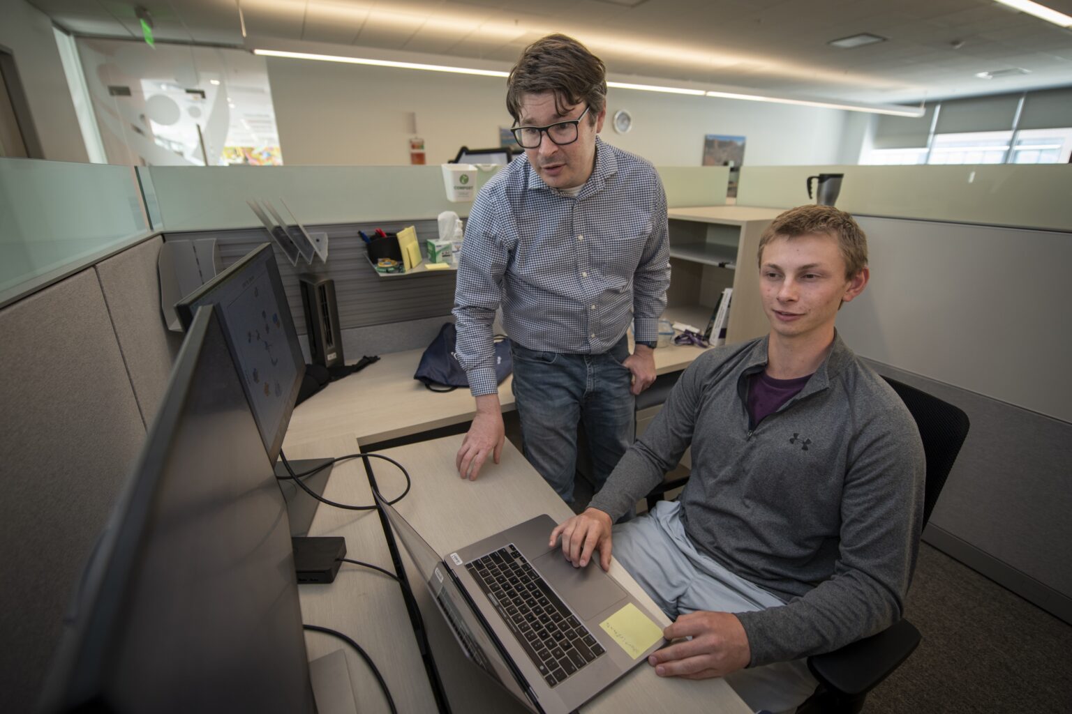 intern with mentor looking at a computer