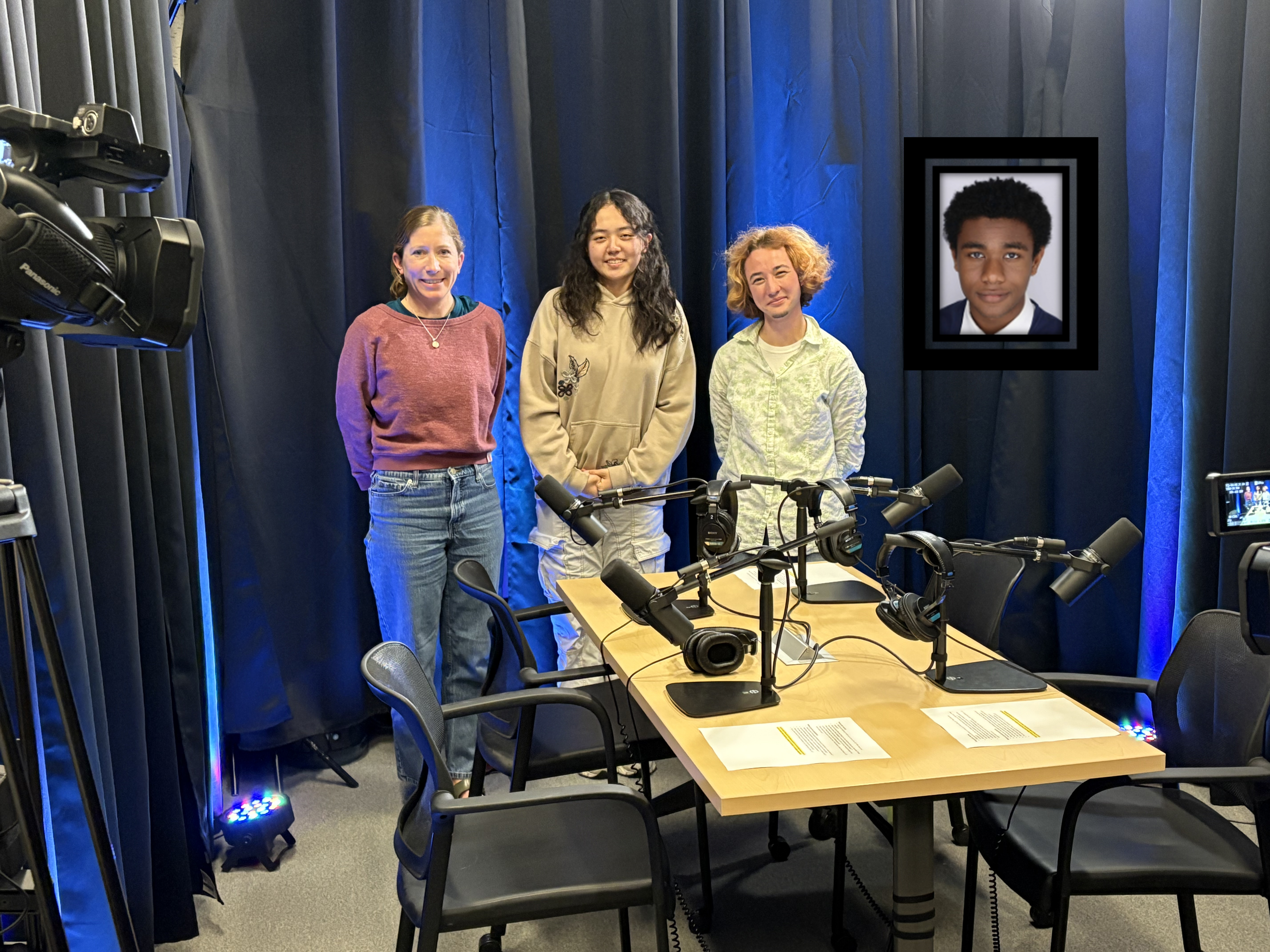 3 people standing in an audio visual studio with a headshot of another person next to them