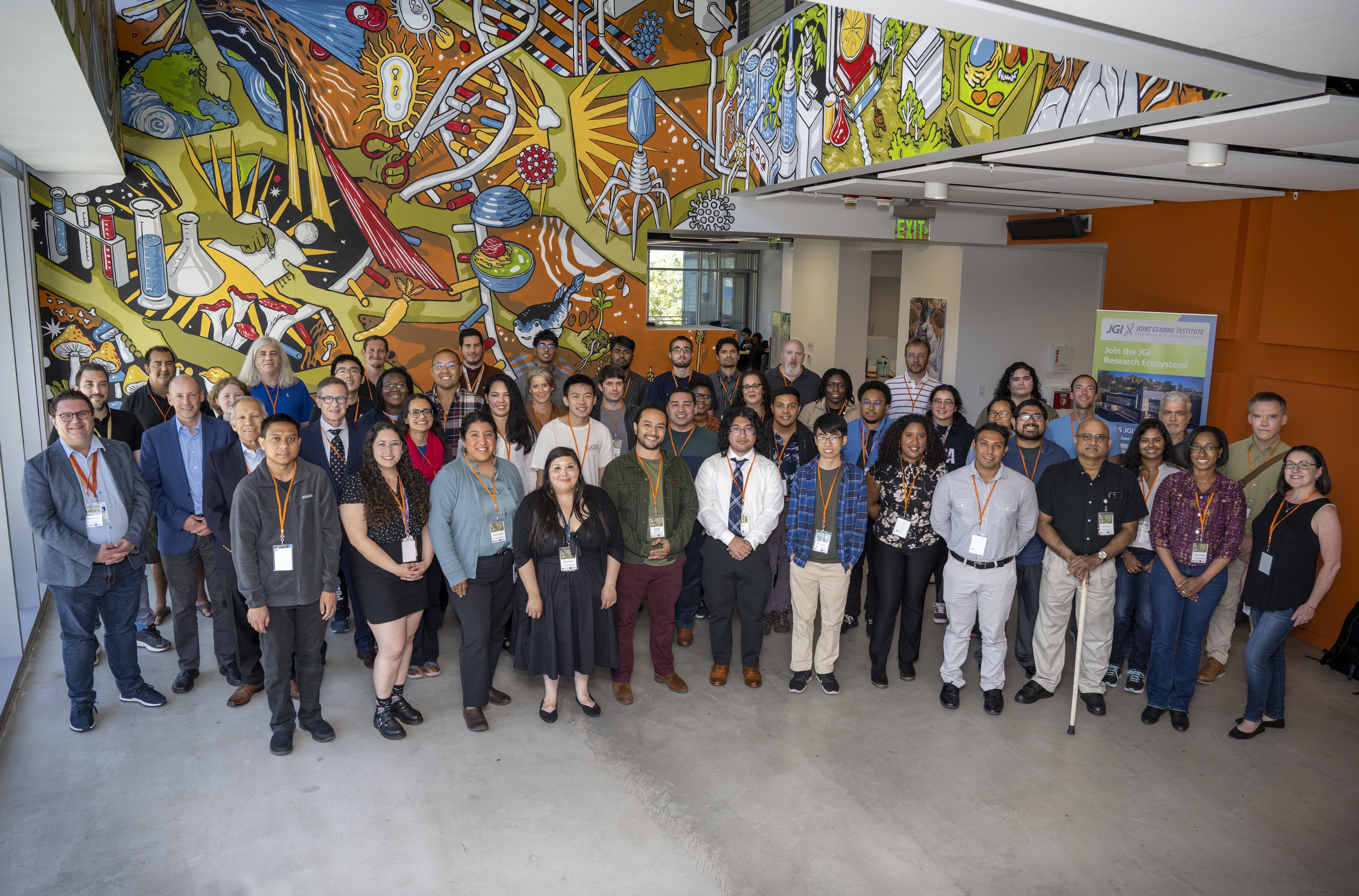 A group shot of the 10 year anniversary of the JGI-UC Merced Internship Program. Mentors and Interns alike pose in front of a mural