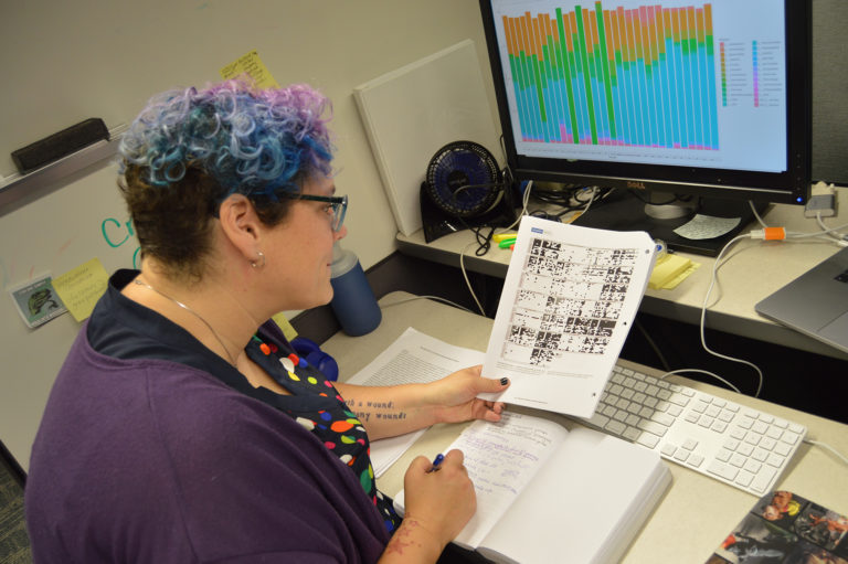 an intern sitting at their desk looing at papers and writing in a book