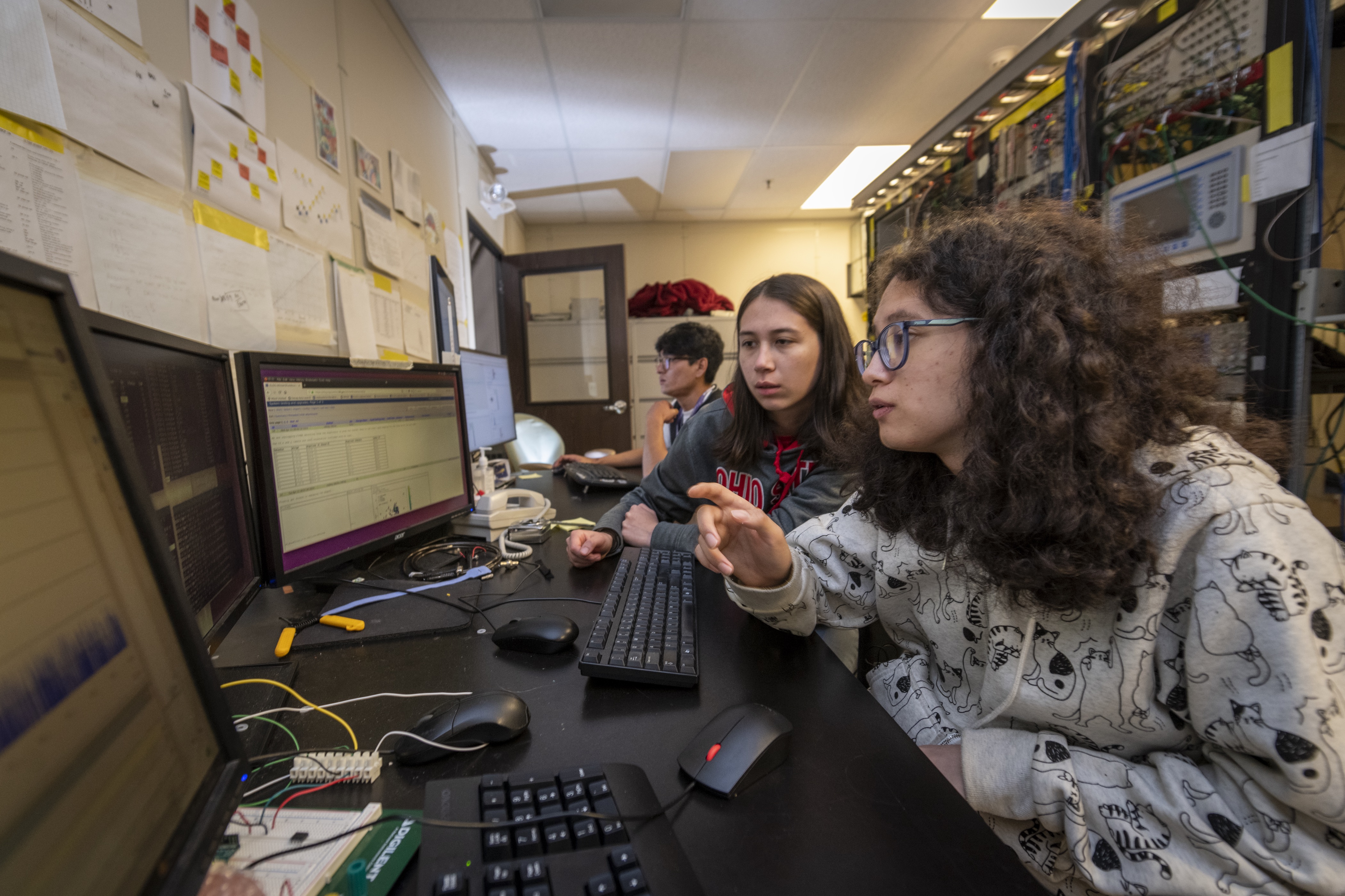 two individuals look and gesture at a computer screen