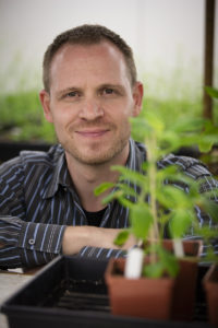 a person in a button up shirt with a plant in front of them