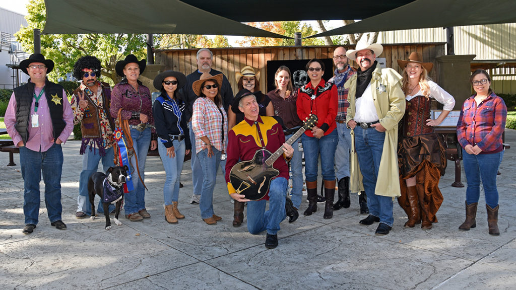 people dressed up in halloween costumes posing for a group photo