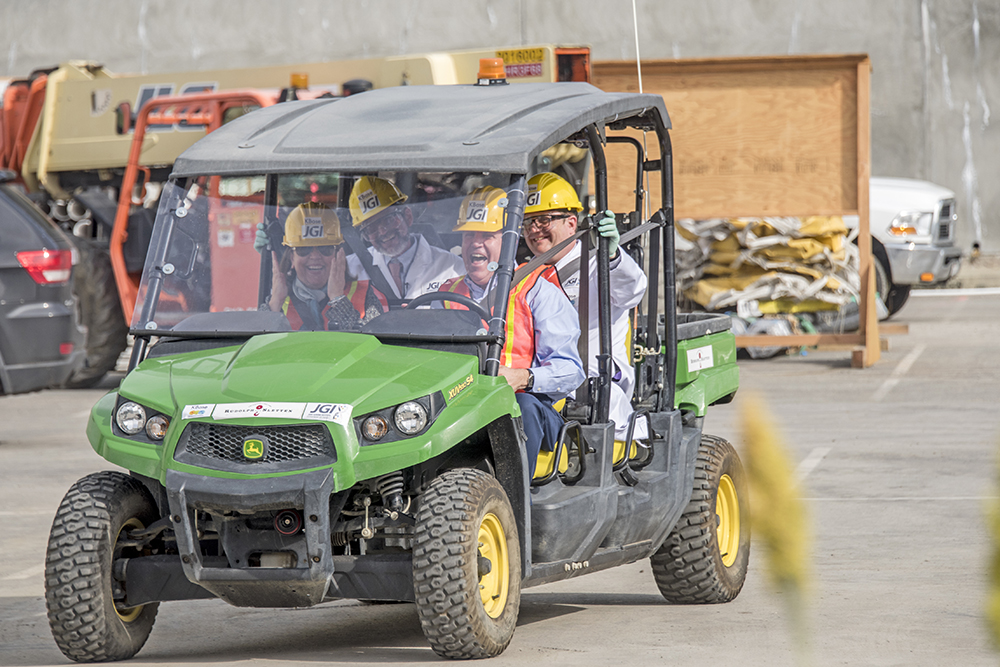 several people riding in a construction cart