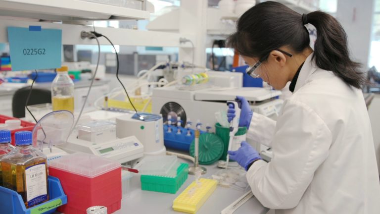 a person in lab gear working in a laboratory