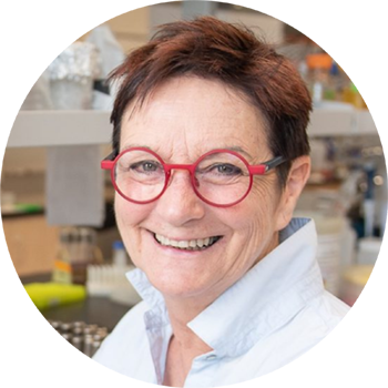 Person in lab wearing shirt with upturned collar and bright red glasses.