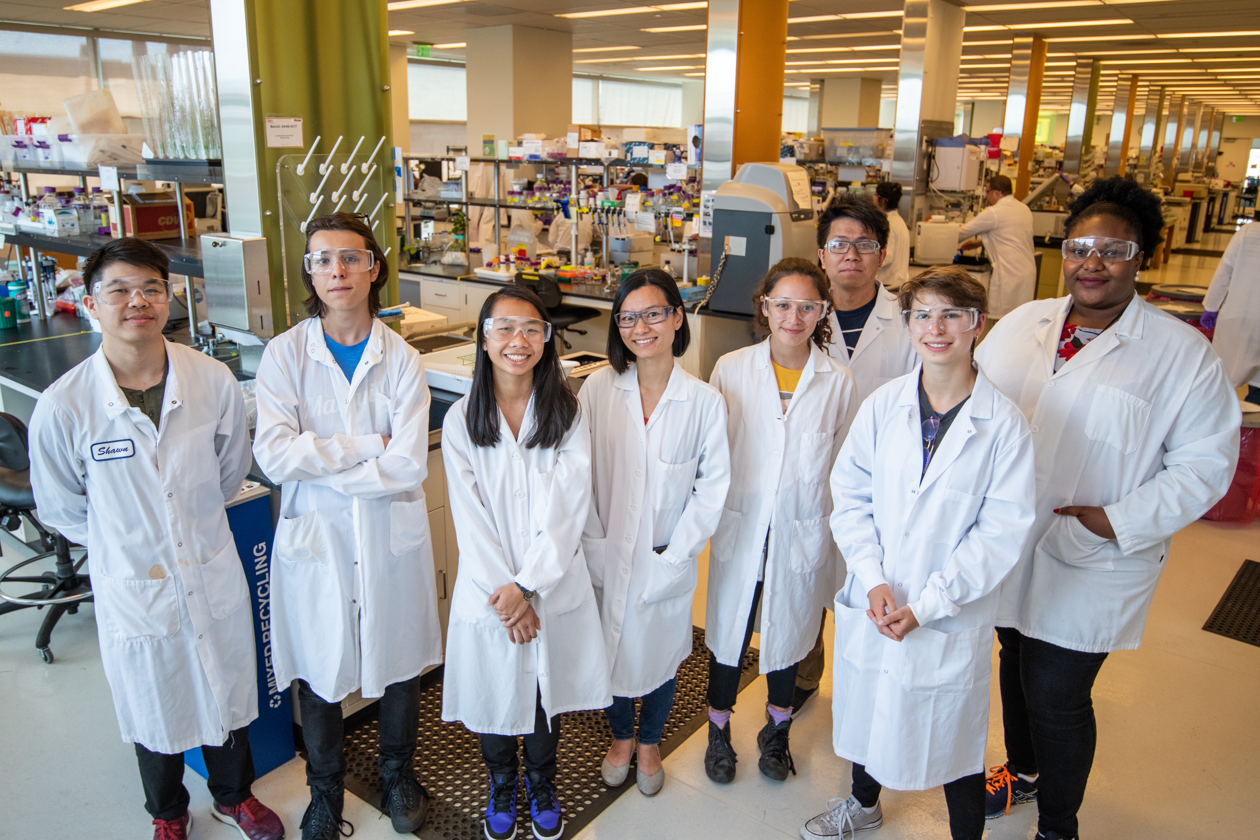 Interns in lab coats standing in a laboratory