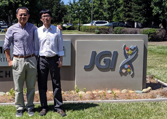 two people standing by a concrete sign