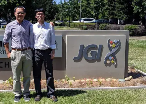 two people standing by a sign