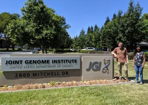 two people standing by a sign