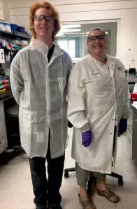 two people in lab gear posing for a photo