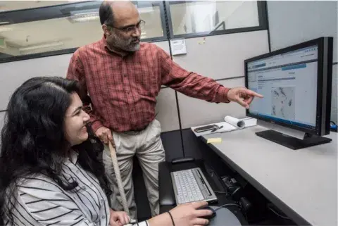 two people looking at a computer