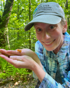 In a blue cap and checked shirt, Ashley smiles and shows off the critter in her hands