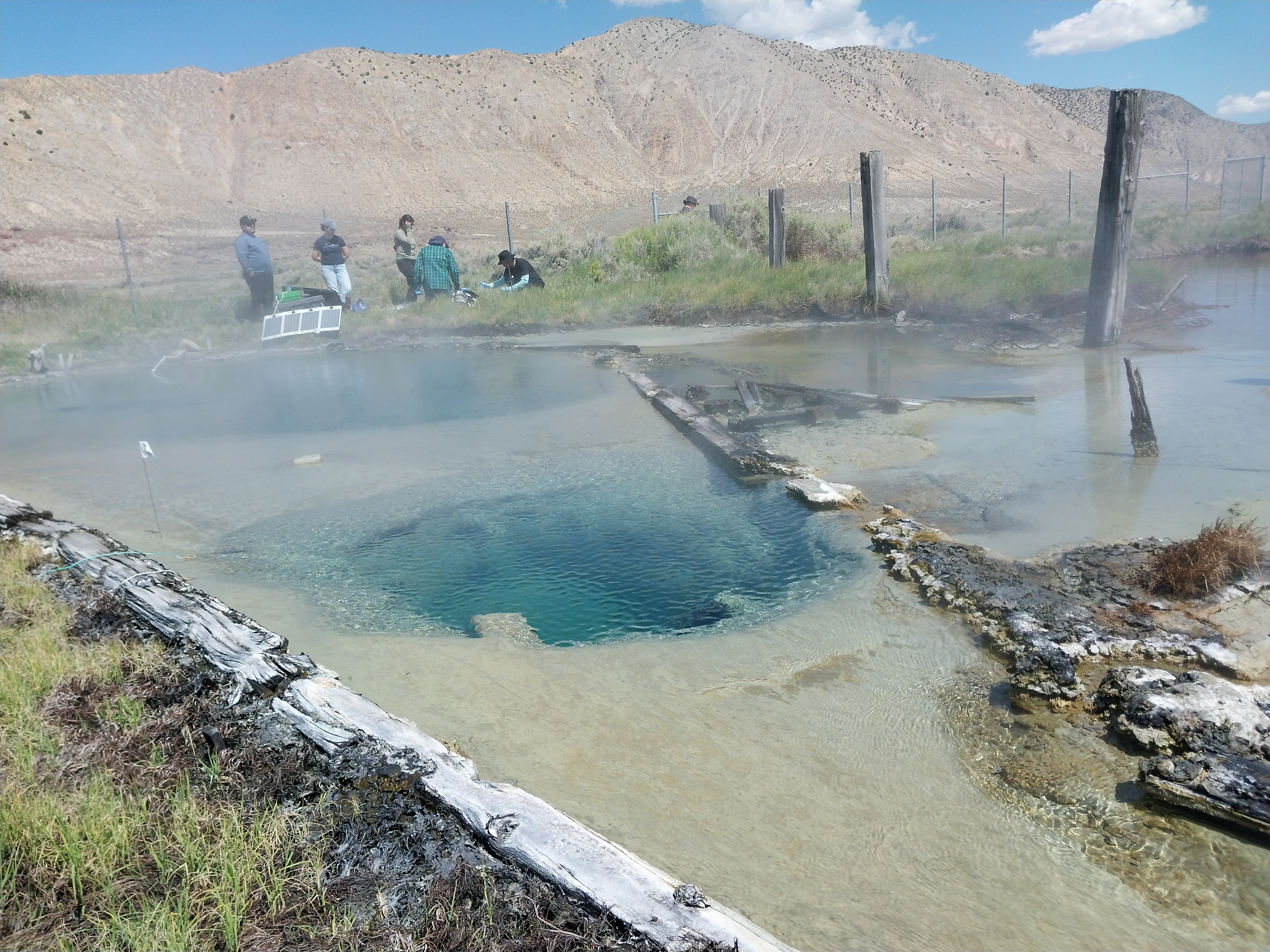 A photo of Great Boiling Spring in the forefront with mountains in the background.